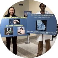 Doctors at the capitol holding posters about gun violence in Georgia