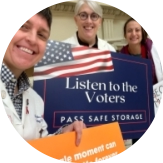 Physicians hold signs that say "Listen to the voters. Pass safe legislation."