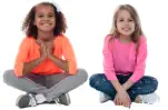 Two little girls sit next to each other looking at the camera. The image represents children who need to be protected from gun violence. 